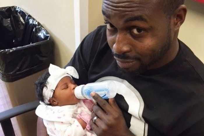 DJ Neptune feeding his daughter
