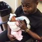 DJ Neptune feeding his daughter