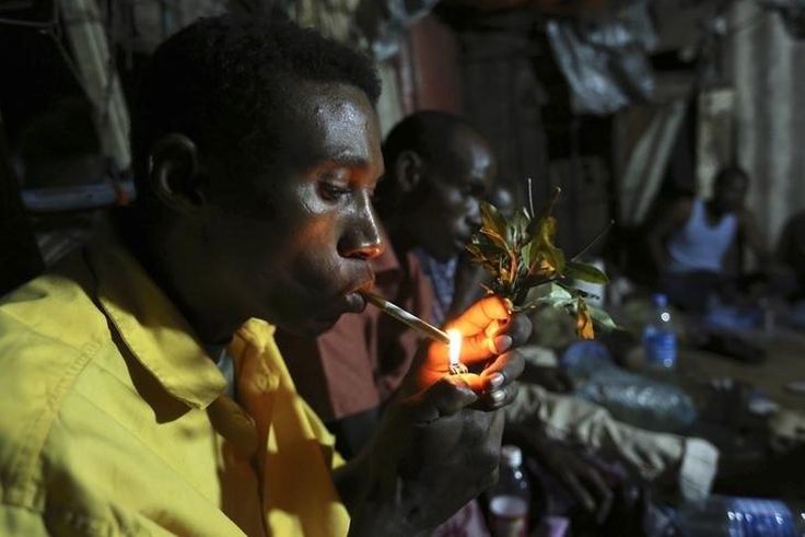 Somali men smoke and chew khat inside a makeshift building at night in Mogadishu August 6, 2014. REUTERS/Feisal Omar