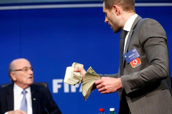 British comedian known as Lee Nelson holds banknotes in front of FIFA President Sepp Blatter (L) at a news conference after the Extraordinary FIFA Executive Committee Meeting at the FIFA headquarters in Zurich, Switzerland July 20, 2015. REUTERS/Arnd W...