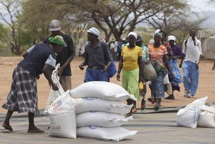 Zimbabweans collect food aid from a distribution point in Mutawatawa, about 220km northeast of the capital Harare, in a file photo. REUTERS/Philimon Bulawayo