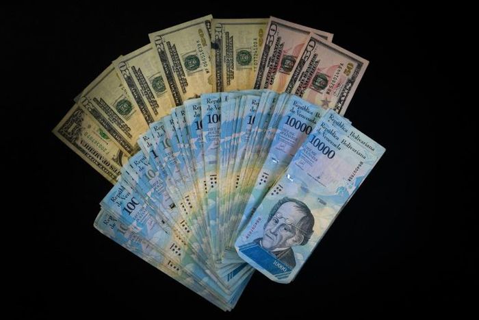 The US is sanctioning seven Venezuelans for allegedly plundering billions of dollars via black-market currency exchanges -- dollars and Venezuela bolivars are seen here