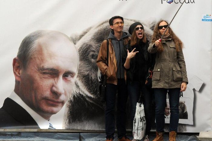 A group of Russians taking selfies with a selfie stick.