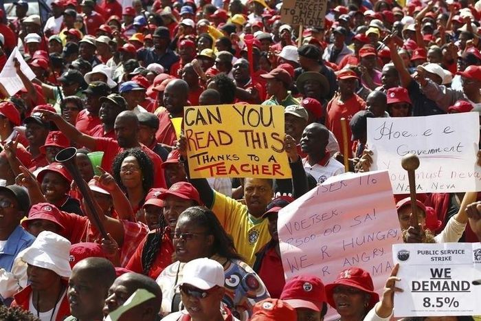 A worker carries a placard during a strike by civil servants outside a hospital in Soweto August 19, 2010.

 Reuters/Siphiwe Sibeko