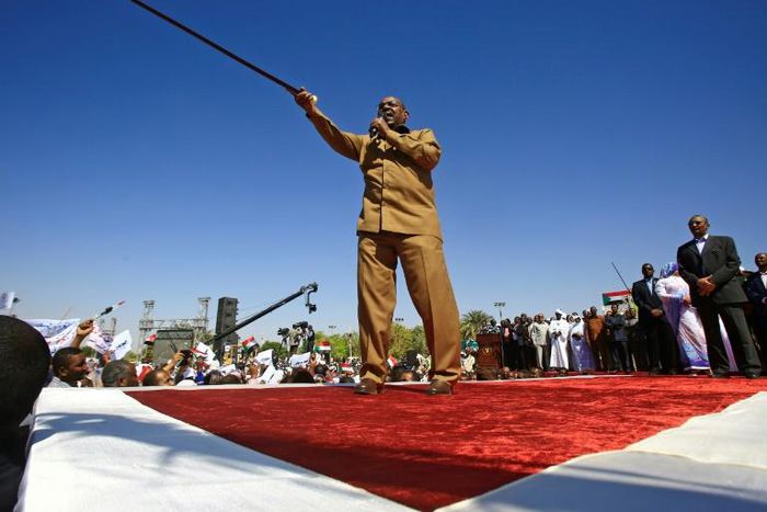 Sudanese President Omar al-Bashir brandishes his trademark cane as he addreses a loyalist rally in Khartoum, the first in the capital since anti-government protests erupted across the country last month
