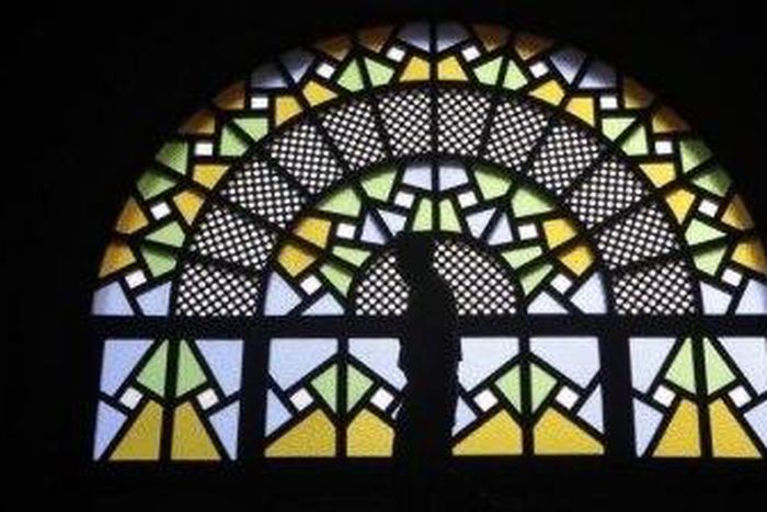 A man walks past stained glass windows inside the Gaddafi National mosque after Friday prayers in Uganda's capital Kampala in this Oct. 21, 2011 file photo. Although Uganda is largely Christian, Hassan Muwanguzi, who converted to Christianity from Isla...