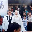 Fethullah Üzümcüoğlu and Esra Polat posing with Syrian refugees on their wedding day