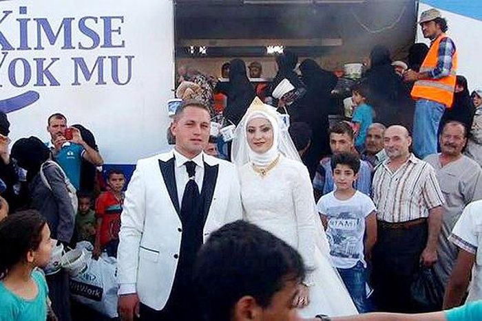 Fethullah Üzümcüoğlu and Esra Polat posing with Syrian refugees on their wedding day