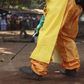 A member of the French Red Cross disinfects the area around a motionless person suspected of carrying the Ebola virus as a crowd gathers in Forecariah January 30, 2015. REUTERS/Misha Hussain