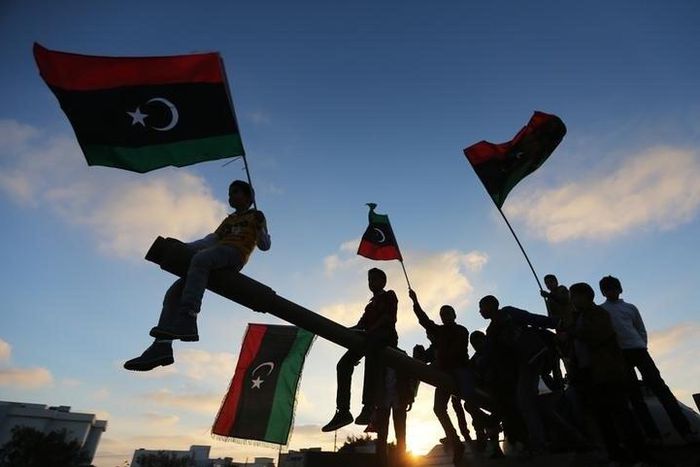 Boys, carrying flags, sit on a tank in Benghazi, March 19, 2014, during the third anniversary of an attack by pro-Gaddafi forces on Benghazi.    REUTERS/Esam Omran Al-Fetori
