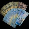 The US is sanctioning seven Venezuelans for allegedly plundering billions of dollars via black-market currency exchanges -- dollars and Venezuela bolivars are seen here