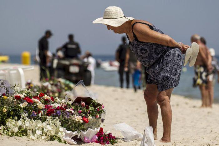 A tourist reads messages left at a makeshift memorial at the beach near the Imperial Marhaba resort, which was attacked by a gunman in Sousse, Tunisia, June 29, 2015. REUTERS/Zohra Bensemra