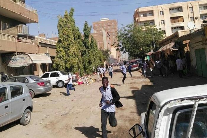 Sudanese protesters run away from tear gas during a demonstration in Khartoum, on December 31, 2018