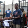 Cassius Kollie (R), 24, one of four people discharged on Monday from an Ebola treatment unit, receives a certificate for being cured of the disease in Paynesville, Liberia, July 20, 2015. REUTERS/James Giahyue