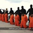 Men in orange jumpsuits purported to be Egyptian Christians held captive by the Islamic State (IS) kneel in front of armed men along a beach said to be near Tripoli, in this still image from an undated video made available on social media on February 1...