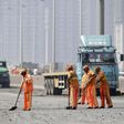  Workers clean debris on a highway near the site of the explosions