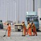  Workers clean debris on a highway near the site of the explosions