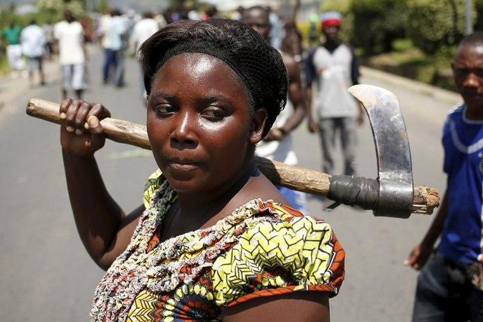 A woman carries an axe during a protest against the president in Bujumbura.