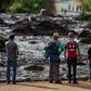 People from the community of Alfredo Torres look at the mud-hit area, a day after the deadly dam collapse