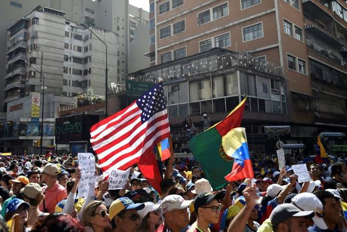 A US flag is seen amid the crowd of supporters of Venezuelan opposition leader Juan Guaido, as people start gathering for a rally to press the military to let in US humanitarian aid, in Caracas on February 12, 2019