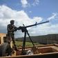 A Somali soldier with a vehicle-mounted heavy machine gun keeps an eye out for danger at the Sanguuni military base south of the capital Mogadishu