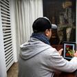 Moroccan Chafik Lafrid looks at a picture of himself on a tablet which went viral, taken after his arrest wearing a dress and a wig