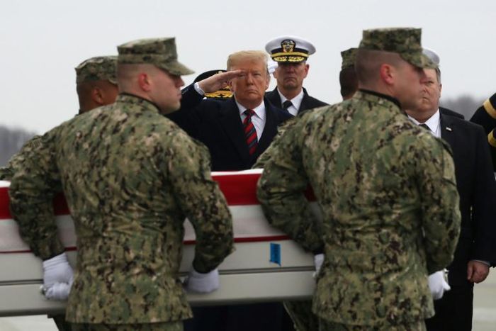 President Donald Trump salutes as the remains of one of four Americans killed in Manbij is returned to the US