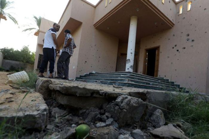 Libyans examine the site where a mortar shell landed in Tripoli during a previous round of deadly clashes between militias on August 30, 2018