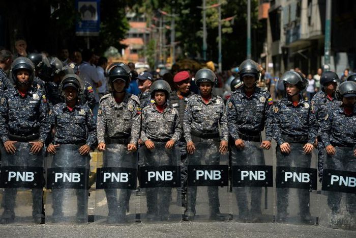 Venezuelan police stand guard near a hospital during a protest against the government of President Nicolas Maduro