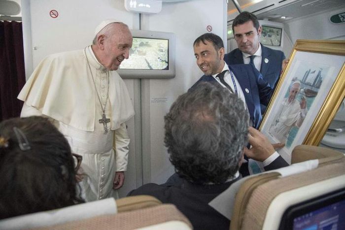Pope Francis, shown here accepting a gift from an Arab journalist aboard the papal plane, said the problem of sexual abuse by priests could be found "anywhere"