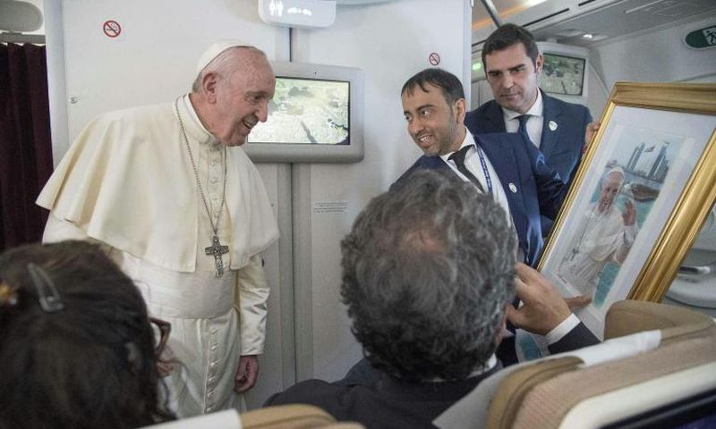 Pope Francis, shown here accepting a gift from an Arab journalist aboard the papal plane, said the problem of sexual abuse by priests could be found "anywhere"