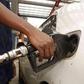 A petrol station attendant fuelling a car