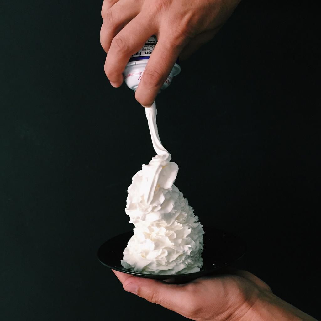 Hand holding a plate with whipped cream