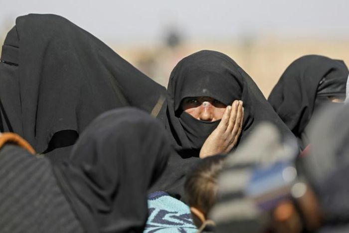 Civilians fleeing fighting between Syrian Democratic Forces (SDF) and Islamic State (IS) jihadists in the frontline Syrian village of Baghuz, wait to be screened in the countryside of the eastern Syrian on February 3, 2019