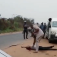 After shooting a traveler dead, a Nigeria Customs Service officer observes his body as if to confirm if he is truly dead.