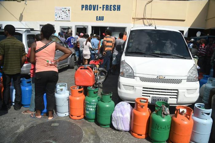 People wait to fill gas cylinders at a station in the Haitian Capital Port-au-Prince