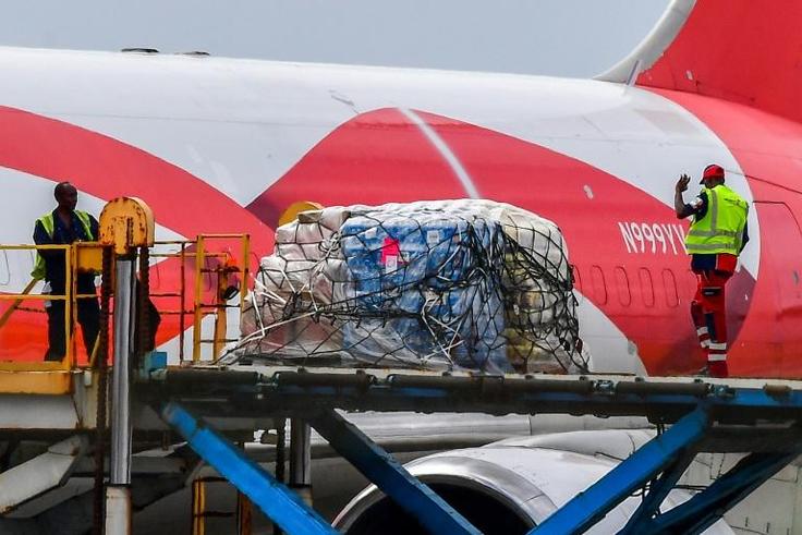 Workers load food and medicals aid for Venezuela from a US Boeing 767 aircraft shortly after landing at the Hato International Airport in Willemstad, Curacao in the Netherlands Antilles on February 21, 2019