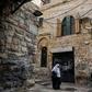 A Palestinian woman walks past a house in the Muslim Quarter of Jerusalem's Old City that was bought by Israeli settlers