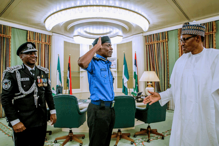 The new Inspector-General of Police (IGP), Mohammad Adamu salutes President Buhari as the outgoing IG, Ibrahim idris watches (Channels TV)