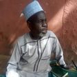 A Quran is positioned close to 61-year-old Abubakar Shettima, who sits on a praying mat to await the commencement of voting. He has visited a polling unit two days earlier than expected. [BBC News]