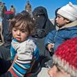 Fully veiled women and children gather after fleeing from the Baghouz area in the eastern Syrian province of Deir Ezzor on February 12, 2019 during an operation by the US-backed Syrian Democratic Forces (SDF) against the Islamic State group