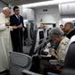 Pope Francis, flanked by Vatican spokesman Alessandro Gisotti (right) anwers journalists questions in the plane following the take off from Panama City on January 27, 2019 after participating in World Youth Day