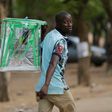 An election official walks away with an empty ballot box at the end of votes count