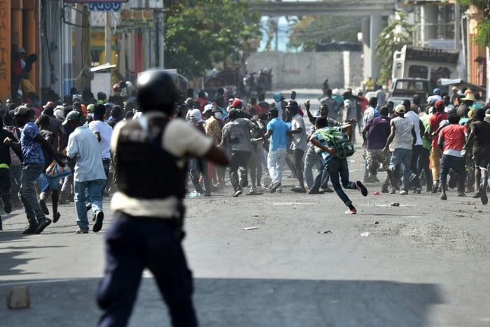 Demonstrators flee as Haitian Police open fire, during the clashes, in the centre of Haitian Capital Port-au-Prince