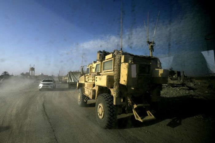A picture taken from inside a car shows US-led coalition vehicles driving through the Syrian village of Baghouz on January 26, 2019