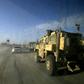 A picture taken from inside a car shows US-led coalition vehicles driving through the Syrian village of Baghouz on January 26, 2019