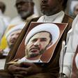 A Bahraini man holds a picture of Sheikh Ali Salman, head of the Shiite opposition movement Al-Wefaq, during a protest on May 29, 2016 against his arrest