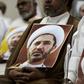 A Bahraini man holds a picture of Sheikh Ali Salman, head of the Shiite opposition movement Al-Wefaq, during a protest on May 29, 2016 against his arrest
