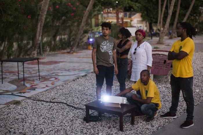 Setting up an outdoors projector to screen a movie near the beach in the Haitian port city of Jacmel, as part of the "Southern Lights" film festival