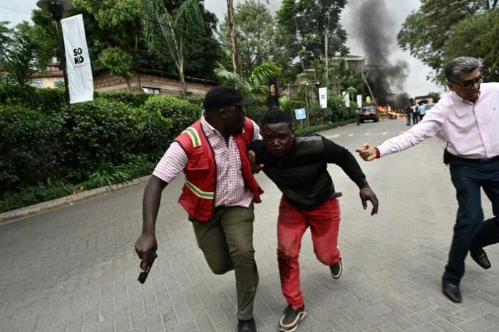 Survivors flee the scene of the attack on an upmarket hotel in the Kenyan capital